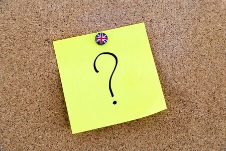 Yellow paper note pinned on cork board with Great Britain flag thumbtack, question mark, United Kingdom exit from European Unionの写真素材