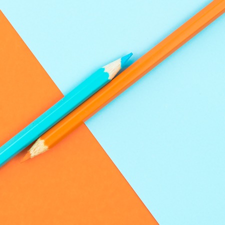 Orange and Turquoise coloured pencils and paper, abstract contrast conceptual imageの写真素材