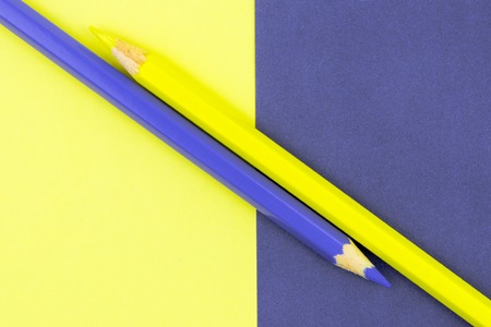 Yellow and Violet coloured pencils and paper, abstract contrast conceptual imageの写真素材