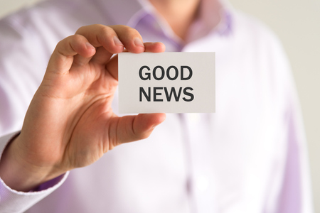 Closeup on businessman holding a card with text GOOD NEWS, business concept image with soft focus backgroundの写真素材