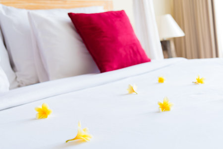 Hotel room with bed and flower arrangement, copy space for textの写真素材