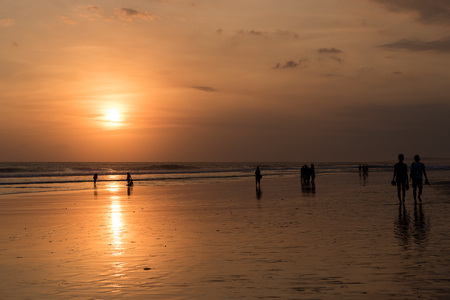 Bali, Indonesia - May 13, 2017: People on Kuta beach in Seminyak at the sunset, a main popular balinese attraction, famous for the clear, aqua blue water and sea food restaurants in Bali, Indonesia.のeditorial素材