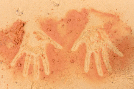Red soil hand shape on sand in aboriginal art style, template for creative projects