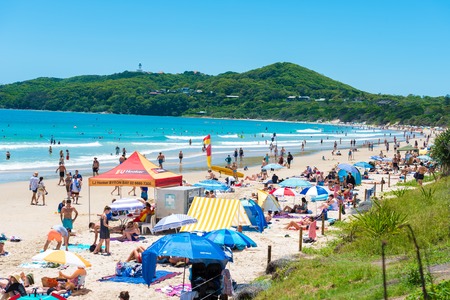 Byron Bay, NSW, Australia- January 3, 2018: People enjoying the sunny weather on the beach at Byron Bay, a popular destination with beaches and coastal trails on the North Coast of NSW, Australia.のeditorial素材
