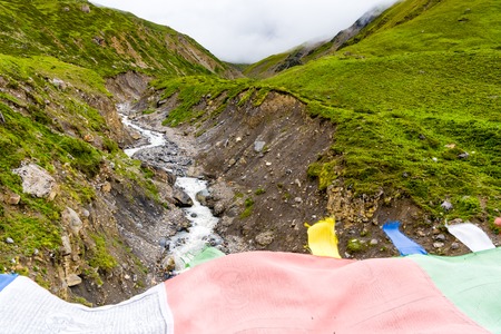 Manang village, Annapurna Conservation Area, Nepal - July 26, 2018 : Traditional buddhist prayer flags over foggy mountain background are used to bless the surrounding countryside and to promote peaceのeditorial素材