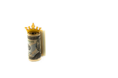Stack of US dollars with golden crown isolated over white background with copy space, cash is king concept imageの写真素材