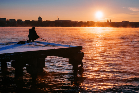 People on the pier watching the sunsetの写真素材