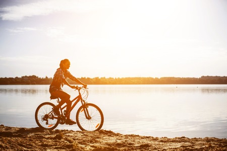 woman on a bicycle near the waterの写真素材