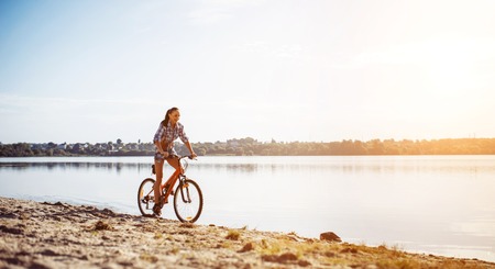 woman on a bicycle near the waterの写真素材