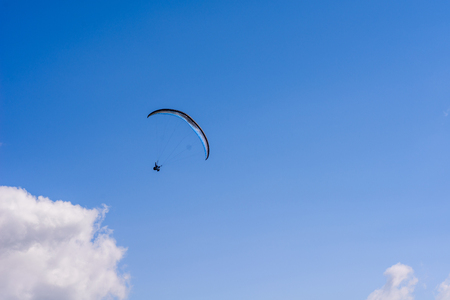 man on a parachute flying in the clear skyの写真素材