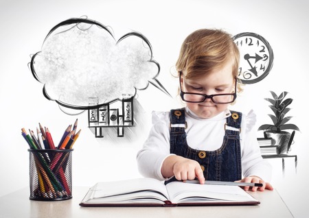 beautiful little girl drawing with multicolored pencils isolatedの写真素材