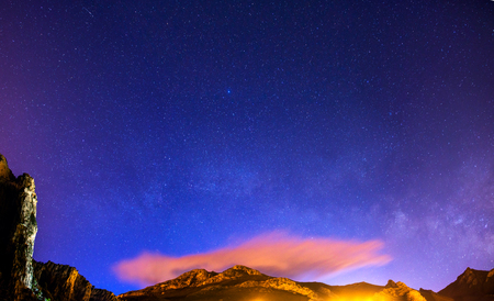 The starry sky above rocky mountains.の写真素材
