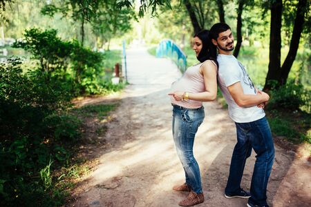 Pregnant woman and her husband relaxing on natureの写真素材