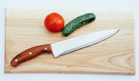 Sliced tomatoes and cucumbers on wooden board.の写真素材