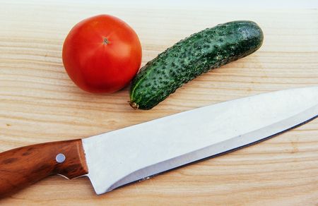 Sliced tomatoes and cucumbers on wooden boardの写真素材
