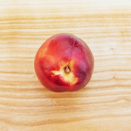 Beautiful fragrant ripe nectarines on the wooden boardの写真素材