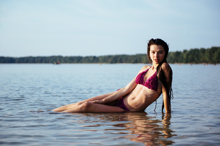 Young beautiful girl posing on the beachの写真素材