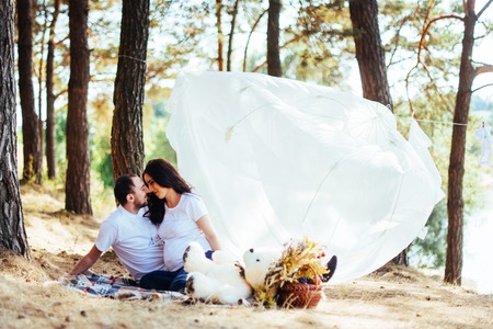pregnant woman with her husband at a picnic.の写真素材