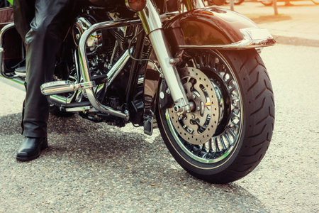 Biker in black boots sitting on a motorcycle