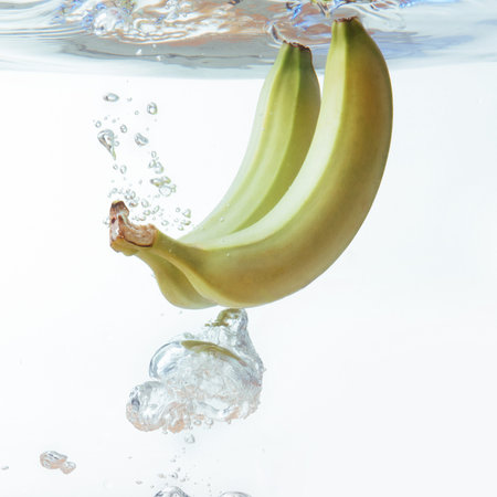 bananas fell into the water, isolated on white.の写真素材