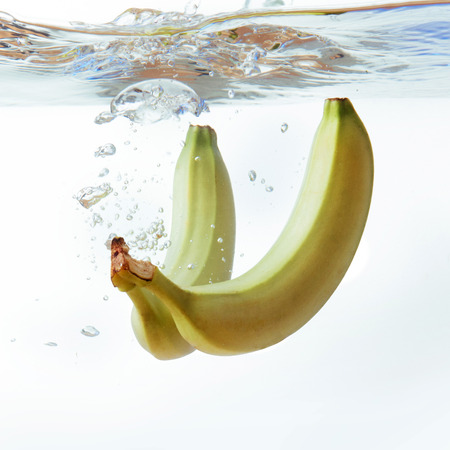 bananas fell into the water, isolated on white.の写真素材