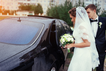 Happy bride and groom near car.の写真素材