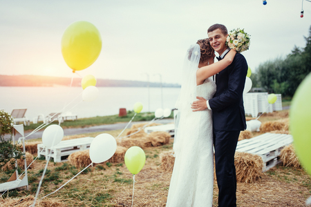 beautiful young wedding couple kissing , blonde bride with floweの写真素材