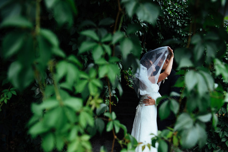 beautiful young wedding couple kissing , blonde bride with floweの写真素材