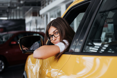 Young woman in her new car smilingの写真素材