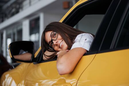 Young woman in her new car smilingの写真素材
