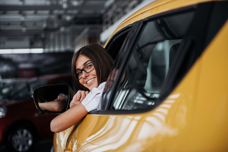 Young woman in her new car smilingの写真素材