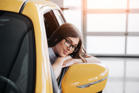 Young woman in her new car smilingの写真素材