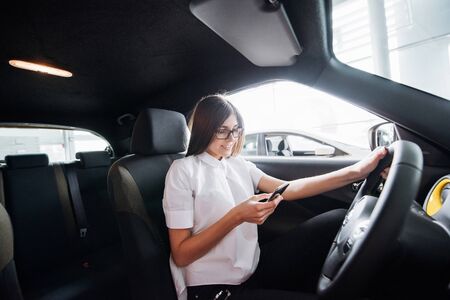 Businesswoman talking on the phone in the carの写真素材