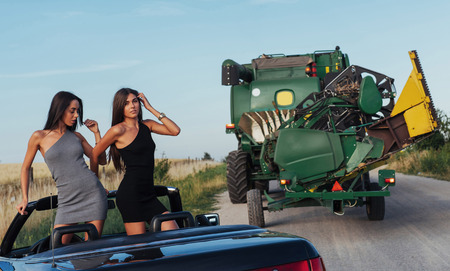 Girls posing for the camera in a black convertibleの写真素材