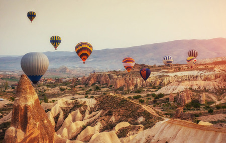 Hot air balloon flying over rock landscape at Turkey. Cappadociaの写真素材