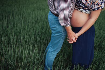 hands and torso of a pregnant woman her husbandの写真素材