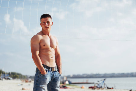 muscular male model with perfect body posing in blue jeans