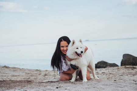 woman playing with her dog on the beachの写真素材