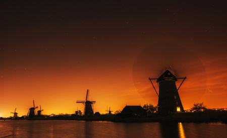Fantastic orange sunset traditional Dutch windmills canal in Rotの写真素材