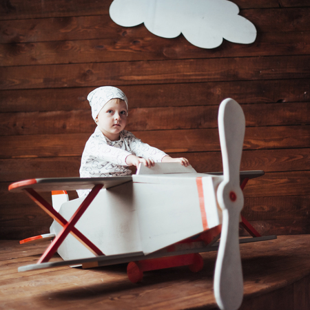 kid playing with wooden airplaneの写真素材