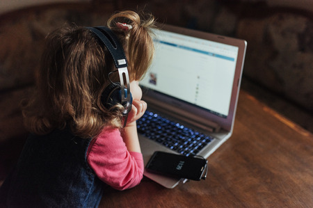 Happy beautiful child in headphones listening to music.の写真素材