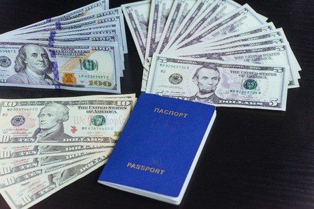 Top view of passport with dollar banknotes on wooden desktopの写真素材