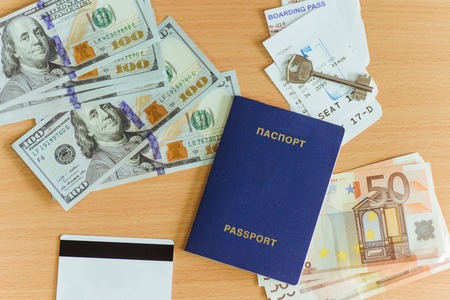passport, dollars, key, and bank card on a wooden background.の写真素材