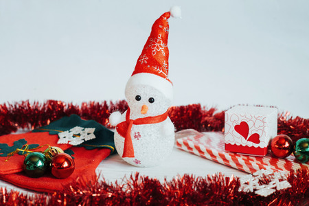Light snowman doll and Christmas decorations on a white wooden bの写真素材