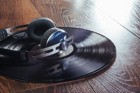 vinyl record and headphone over wooden table.