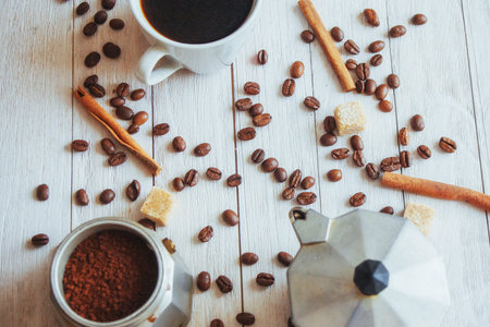 Coffee beans and cup of coffee on table on background.