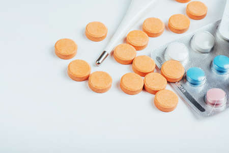 Flu. Thermometer with elevated temperature and many pills on light background.の写真素材