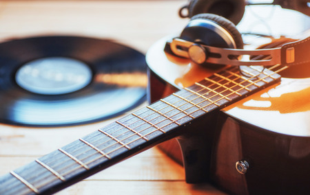 Classical guitar with headphones on a wooden background.の写真素材