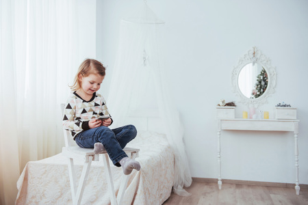 Child in soft warm pajama playing in bed.の写真素材