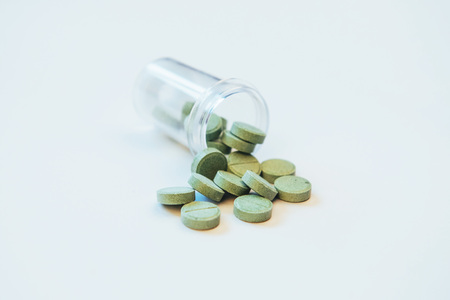 Medical green pills for treatment and health care on a white background.の写真素材